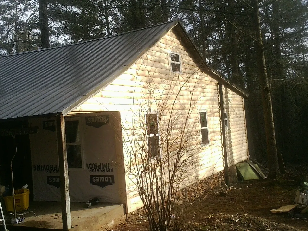 Log siding gable end under a dark metal roof edge in Sweeden