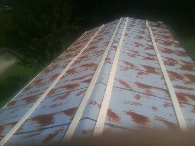 Rusted metal roof panels with new wood purlins before replacement — Storm Damage Roof Repair in Sweeden by Roofing Brothers