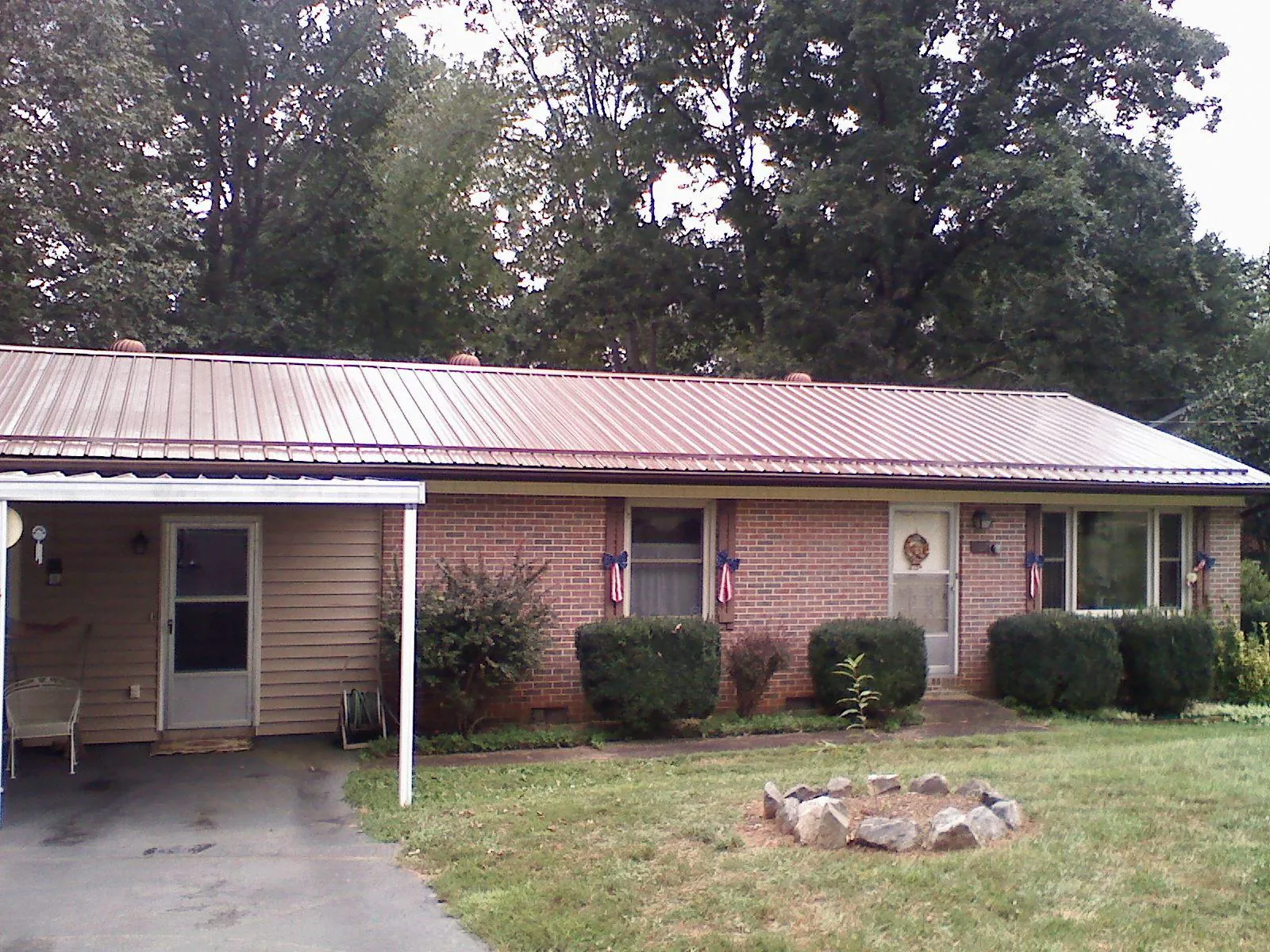 Bronze metal roof and carport on a brick ranch home — Roof Repair work by our crew in Sweeden